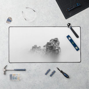 Isolated rock in a mist of sea desk mat