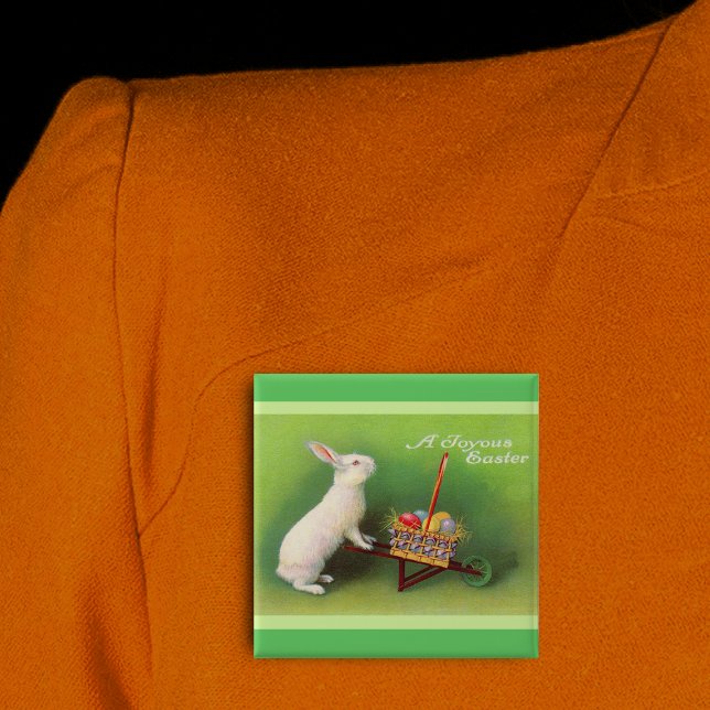 Joyous Easter Rabbit Basket Eggs 15 Cm Square Badge (Joyous Easter white rabbit pushing wheelbarrow coloured eggs on green pin back button.)