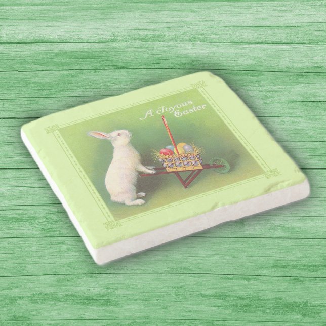 Joyous Easter White Rabbit Basket Eggs Wheelbarrow Stone Coaster (White rabbit pushing wheelbarrow full of colored Easter eggs on green stone drink coaster.)