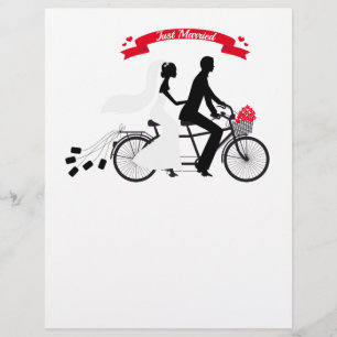 Just married bride and groom on tandem bicycle