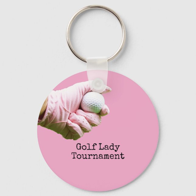 Lady golfer is holding golf ball on pinkbackground key ring (Front)
