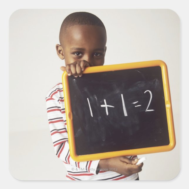 Learning arithmetic. 4-year-old boy holding a square sticker (Front)