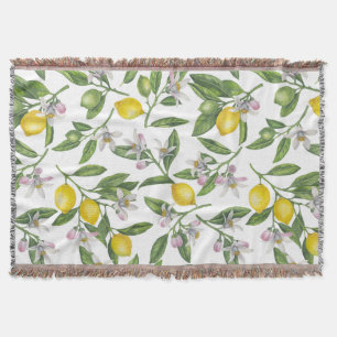 Lemon branches with blossoms and fruit on white throw blanket