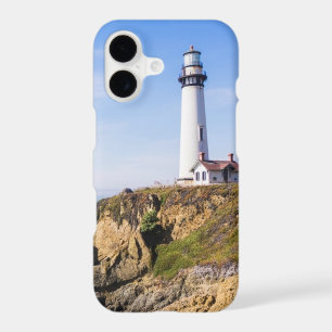 Lighthouse on hill blue sky white house ocean
