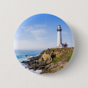 Lighthouse on hill blue sky white house ocean 6 cm round badge