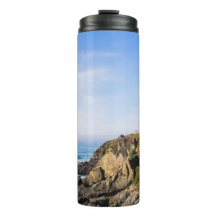 Lighthouse on hill blue sky white house ocean thermal tumbler