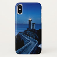 Lighthouse on wall in ocean at night