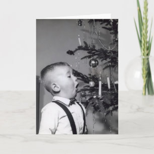 Little boy blows out candle on Christmas tree Holiday Card