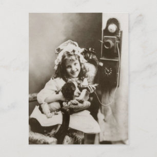Little girl and puppy playing with telephone postcard