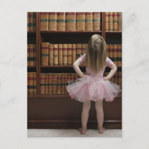 little girl in tutu reading book covers in postcard