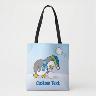 Little penguin getting a snow ball tote bag