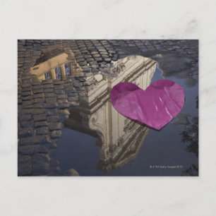 Lonely paper heart floating in a puddle. postcard