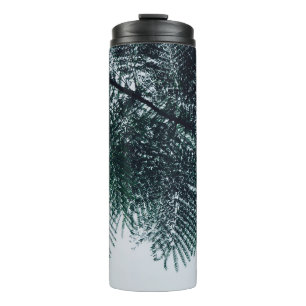 Low-angle photo of green tree thermal tumbler