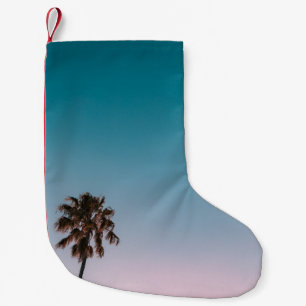 Low-angle photograph of three palm trees under blu small christmas stocking