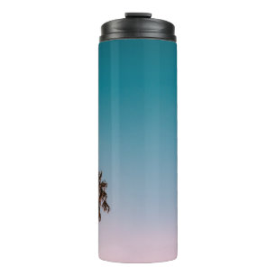 Low-angle photograph of three palm trees under blu thermal tumbler