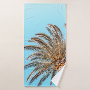Low-angle photography of a green palm tree under a bath towel