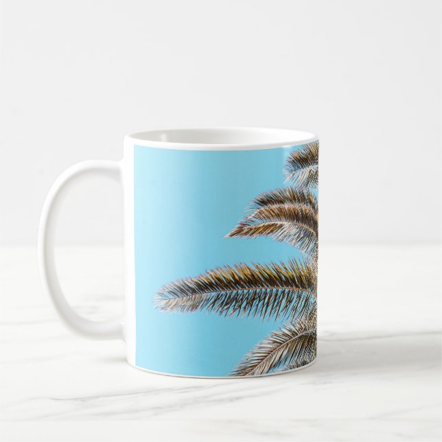 Low-angle photography of a green palm tree under a coffee mug (Left)