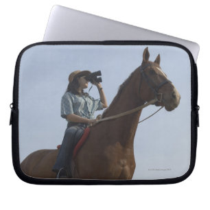 Low angle view of a teenage girl riding a horse laptop sleeve