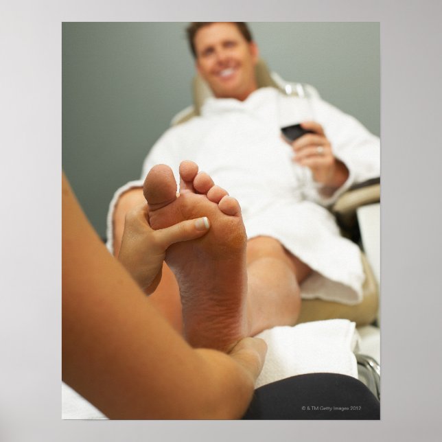 Low angle view of man receiving foot massage poster (Front)