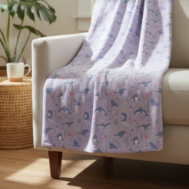 Magical Dolphin Nursery, Whimsical Underwater Deco Fleece Blanket (Dolphin pattern fleece blanket in lavender draped over a sunlit couch.)