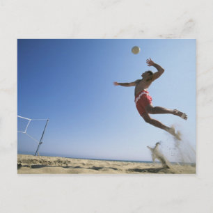 Male beach volleyball player jumping up to spike postcard