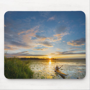 Male kayaker paddling sea kayak on still water mouse mat