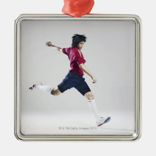 Male soccer player preparing to kick ball metal tree decoration