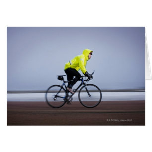 Man bicycles on a cold and foggy winter day.
