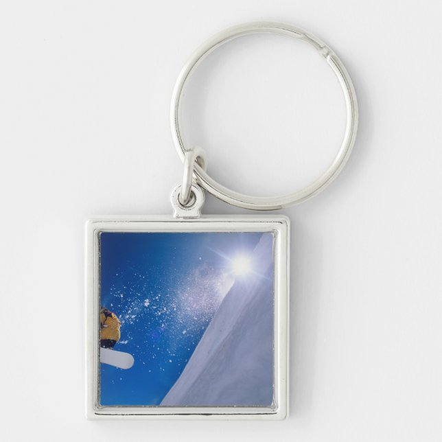 Man flying through the air on a snowboard with key ring (Front)