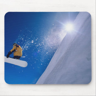 Man flying through the air on a snowboard with mouse mat