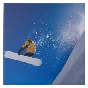 Man flying through the air on a snowboard with tile