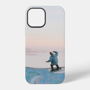 Man in blue skateboarding on wall in beach iPhone 12 case