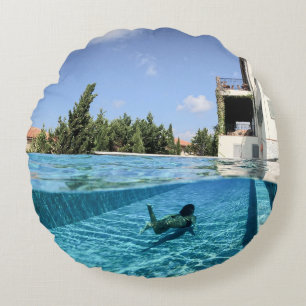 Man in swimming pool in the morning round cushion