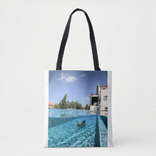 Man in swimming pool in the morning tote bag
