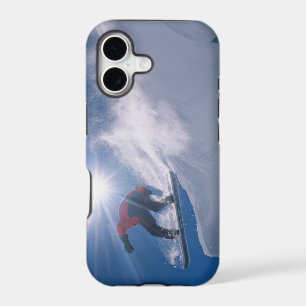 Man jumping off a large cornince on a snowboard