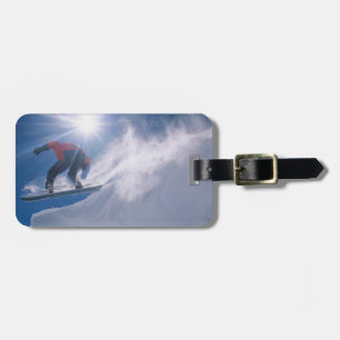 Man jumping off a large cornince on a snowboard luggage tag