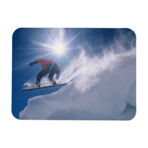 Man jumping off a large cornince on a snowboard magnet