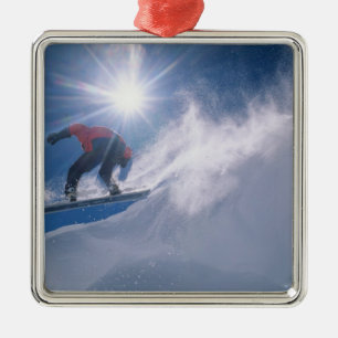 Man jumping off a large cornince on a snowboard metal tree decoration