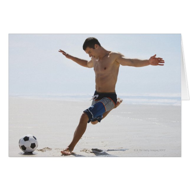 Man kicking soccer ball on beach (Front Horizontal)