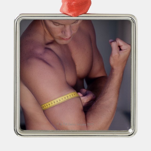 Man measuring bicep metal tree decoration (Front)
