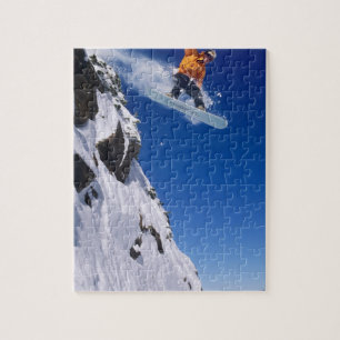 Man on a snowboard jumping off a cornice at jigsaw puzzle