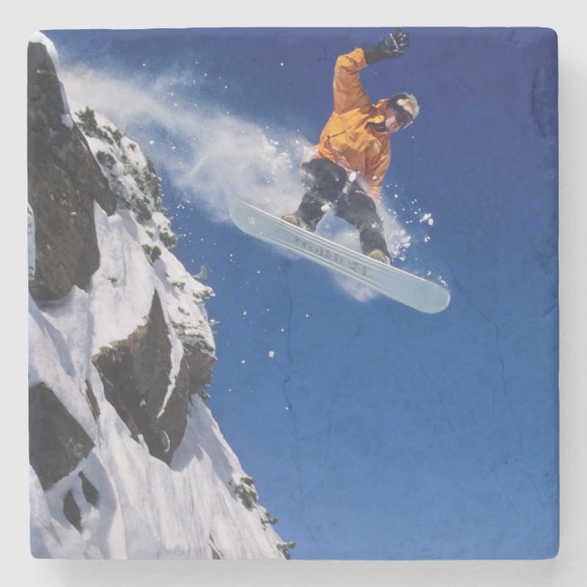 Man on a snowboard jumping off a cornice at stone coaster (Front)