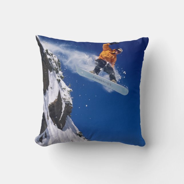 Man on a snowboard jumping off a cornice cushion (Front)