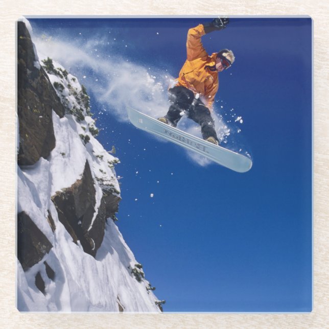 Man on a snowboard jumping off a cornice glass coaster (Front)