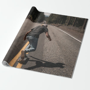 Man playing skateboard on road in the morning wrapping paper