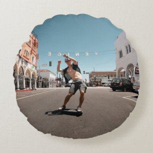 Man playing skateboard round cushion