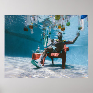Man sitting on chair underwater with floating bott poster