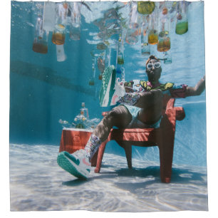 Man sitting on chair underwater with floating bott shower curtain