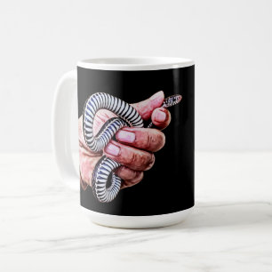 mans hand holding baby snake reptile art coffee mug