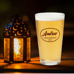 Maroon Stylised Wedding Groomsman Name Glass<br><div class="desc">Beer glass for the wedding groomsman that features his name printed in dark maroon,  stylised script inside a maroon colour oval border along with wedding date. A great party supply idea for a bachelor party! Personalise your beer glass by editing and replacing name and date with your own.</div>